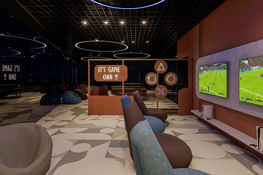 The indoor games room, with console seating facing wall-mounted screens.